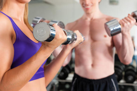 运动夫妻俩在健身房用杠铃锻炼