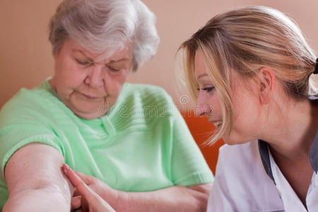 老年护士照顾老年妇女手臂