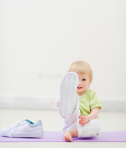 婴儿穿着大运动鞋在镜头前踢腿
