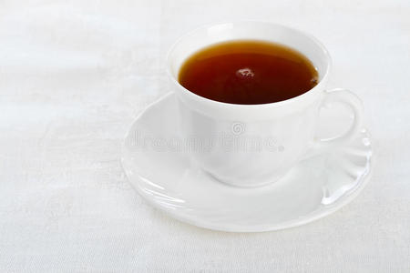 白餐巾上的茶杯。