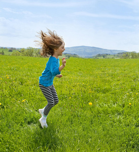 小女孩在春天的草地上跳