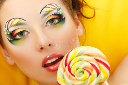 女人用漂亮的化妆品舔糖果