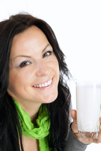 微笑的黑发女人拿着牛奶