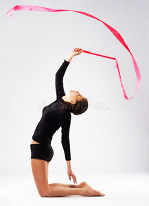 年轻女子体操运动员用缎带训练图片