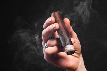男人雪茄手拿抽着棕色雪茄的男人照片