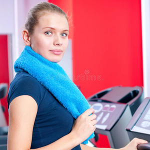 健身房的年轻女子在机器上跑步