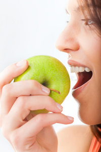 年轻女子咬一个新鲜健康的苹果