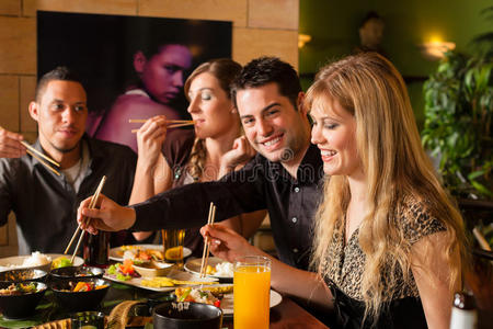 阿卡泰佩克在泰国餐馆吃饭的年轻人照片