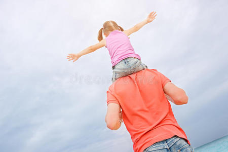 在妈妈肩上蹒跚学步的孩子坐在父亲肩上的玩具飞机男孩年轻男孩棒球