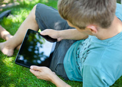 一个年轻人在户外使用平板电脑
