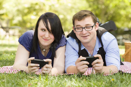 公园里的一对年轻夫妇一起发短信