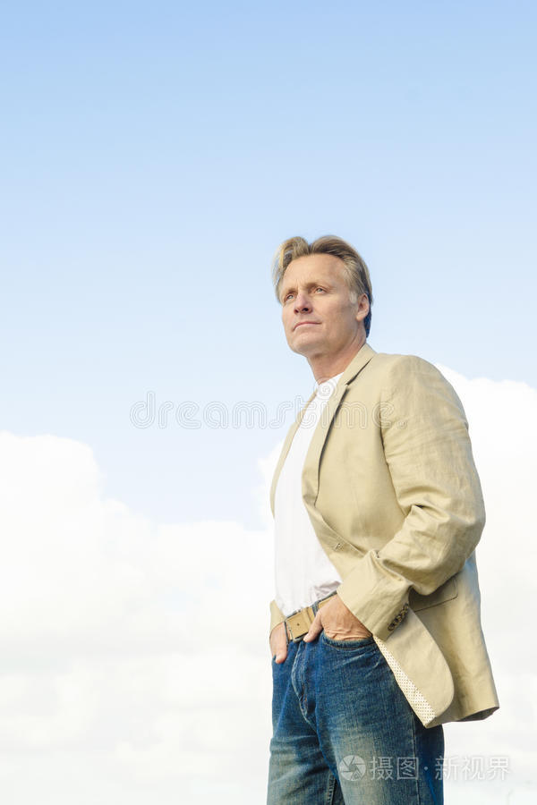 一个穿着米色ja的男人站在侧面