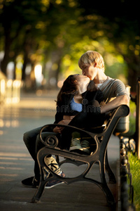 在街上坐在长凳上的年轻夫妇。