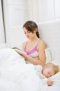 妈妈在卧室看书，而宝宝在睡觉