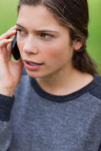 年轻严肃的女孩在打电话