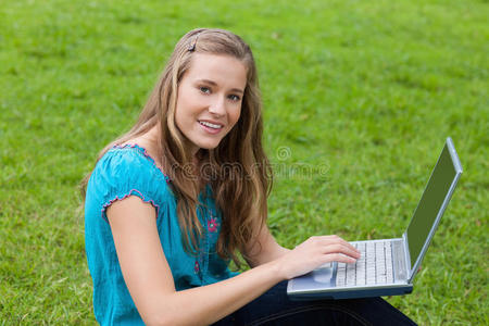 小女孩在公园里用笔记本电脑