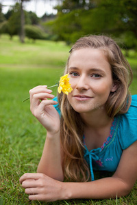 在公园里抱着一朵黄花的女孩