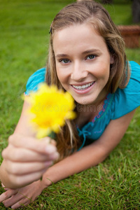 微笑的年轻女子捧着一朵黄花