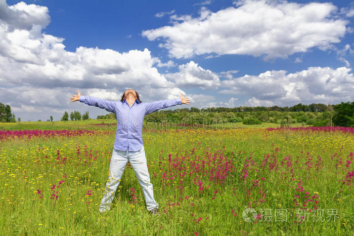 站在蓝天背景下的草地上的人