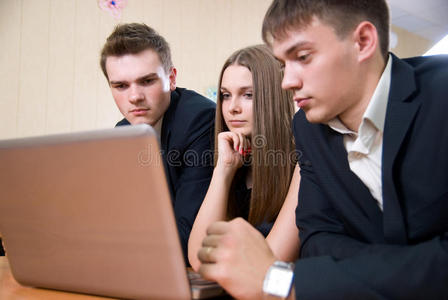 三个拿着笔记本电脑的年轻商人