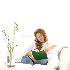 在沙发上看书的年轻白人妇女
