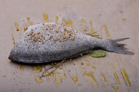 用香草和橄榄油在烤纸上烤生鱼。