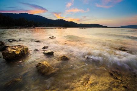 日落时在海滩上挥手