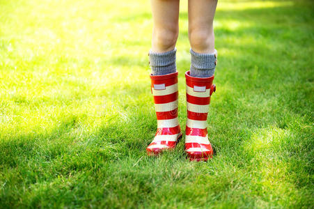 小女孩穿着红色雨靴在玩橡胶青蛙漂亮的小女孩穿着红色雨靴在玩玩具