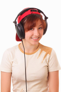 有趣的年轻女孩用耳机听音乐
