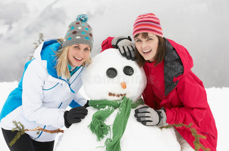 两个女朋友在滑雪度假时堆雪人图片