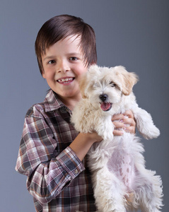 快乐的男孩抱着他的毛茸茸的狗