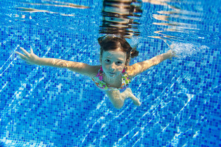 游泳池里快乐微笑的水下孩子