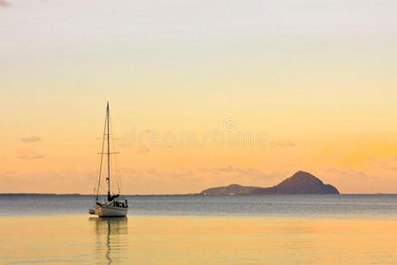 日落时平静海面上的帆船图片