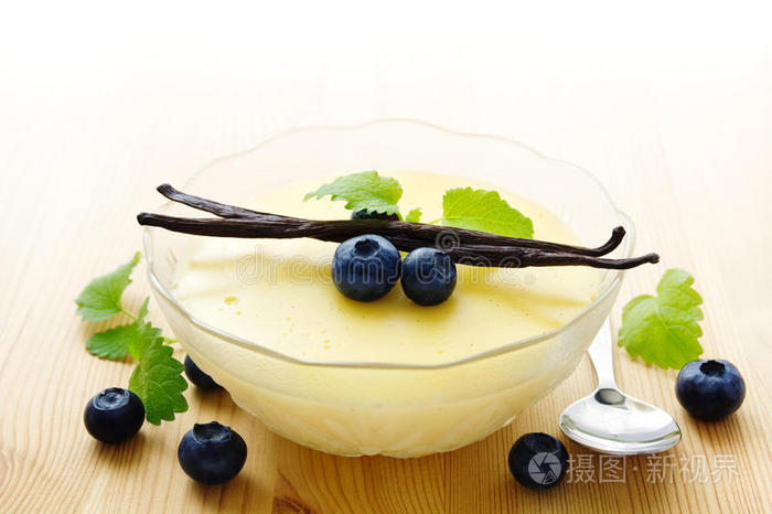 布丁透明玻璃方碗里的李子酱桌子上的eclar甜点巧克力甜点奶油焦糖