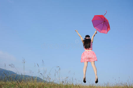 女人拿着红伞跳上蓝天