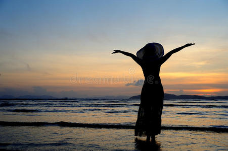 泰国海边夕阳中的快乐女人