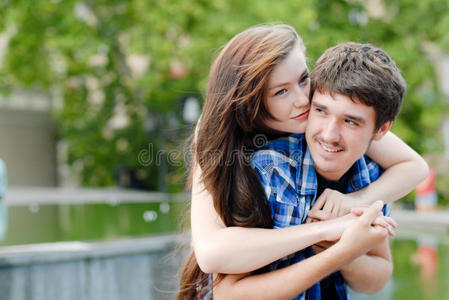 欢笑的年轻夫妇在户外拥抱