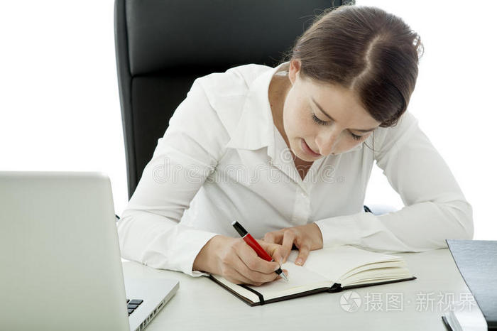 年轻的黑发女商人在书中写字