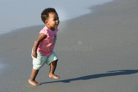 在海滩上奔跑的非裔美国幼儿