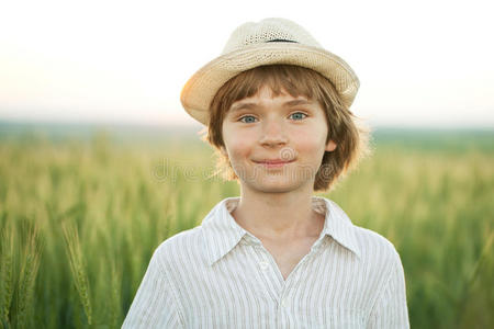 戴着帽子的快乐男孩在麦田里