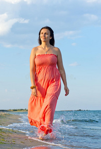 穿长裙的女人在海浪中漫步