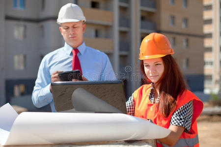 两位建筑师在建筑工地前工作