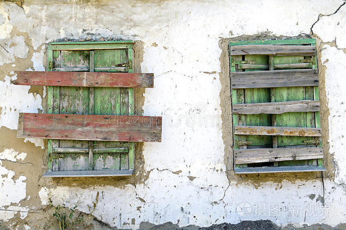 两扇用木板封住的旧窗户