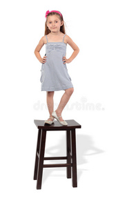穿衣服的小女孩站在凳子上