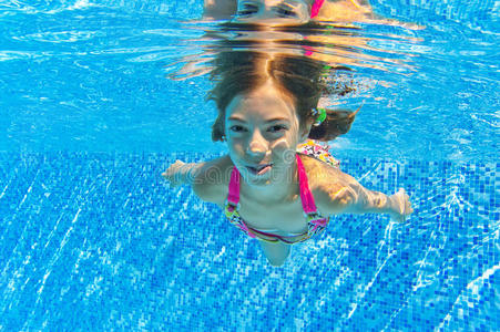 游泳池里快乐微笑的水下孩子
