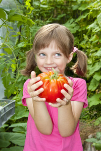抱着一个大红西红柿的小女孩