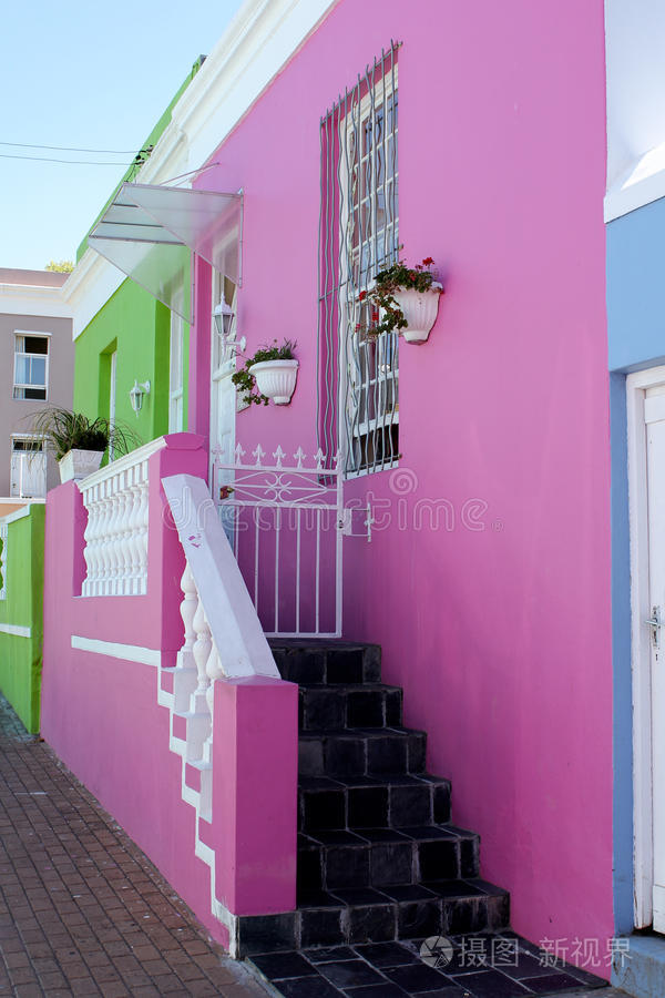 粉红色和绿色的房子前面