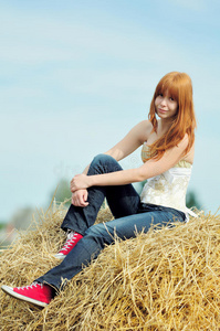 坐在干草上快乐微笑的小女孩