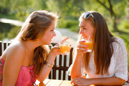 两个快乐的女朋友在露台咖啡厅聊天照片