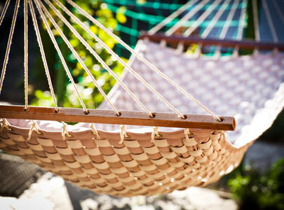 悬挂在阳光明媚的院子里的吊床